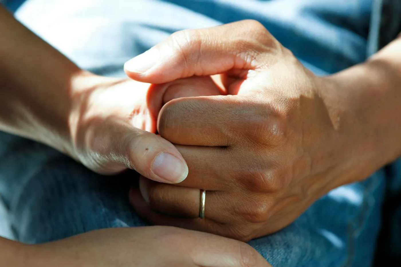 Two people holding hands in comfort