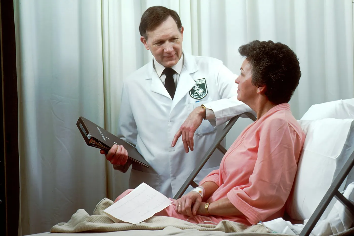 Doctor talking with a patient in a hospital bed